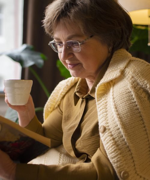 medium-shot-old-woman-reading-home